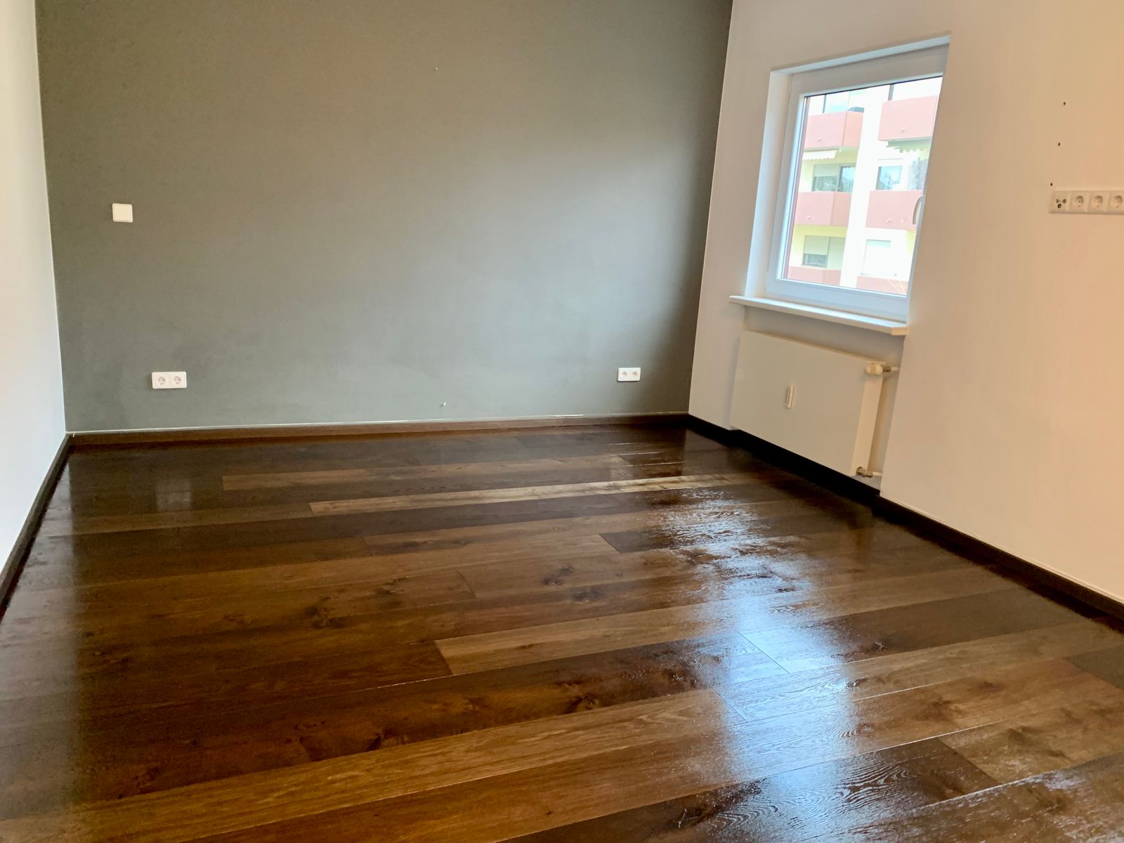 Fertiger Flur mit dunklem Dielenparkett und Einbauschrank