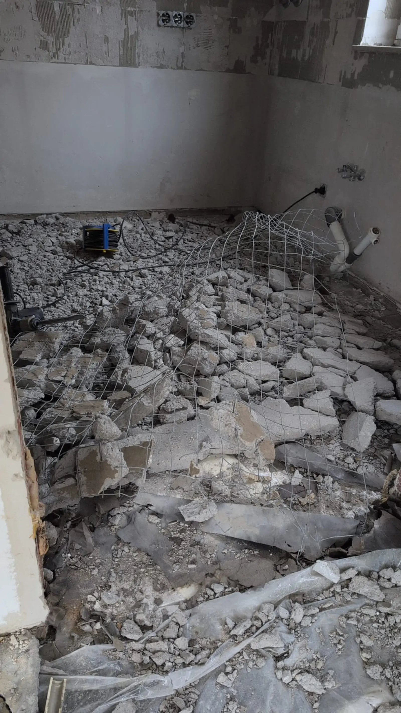 Innenabbruch: Bauschutt und freigelegte Bewehrung auf dem Rohboden