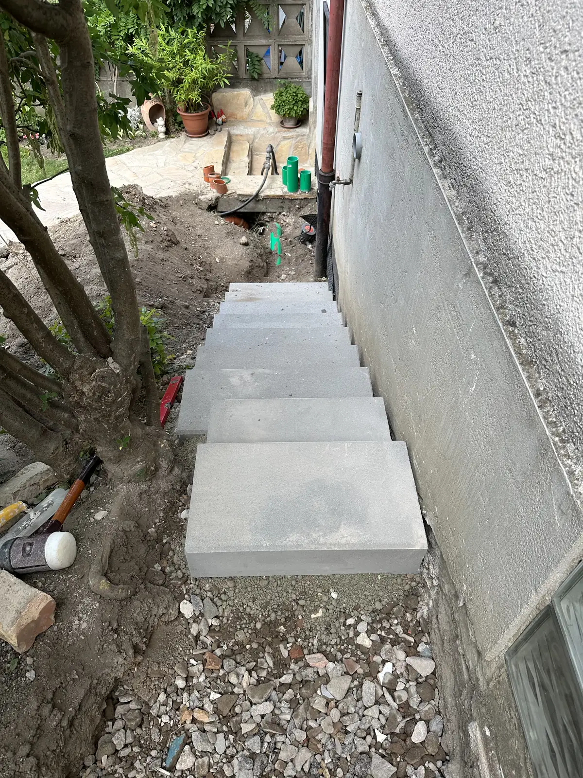 Neue Außentreppe aus Betonstufen zwischen Hauswand und Böschung