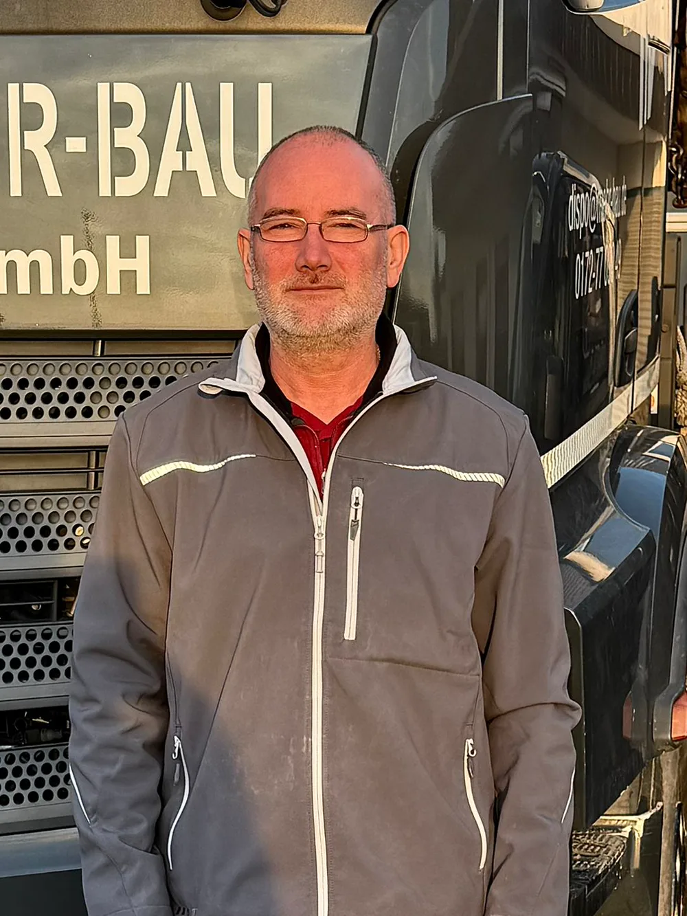Imre, Mitarbeiter der Mehr-Bau GmbH, vor dem Firmen-Lkw