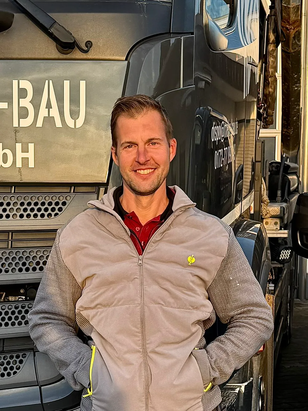 Marc, Mitarbeiter der Mehr-Bau GmbH, vor dem Firmen-Lkw
