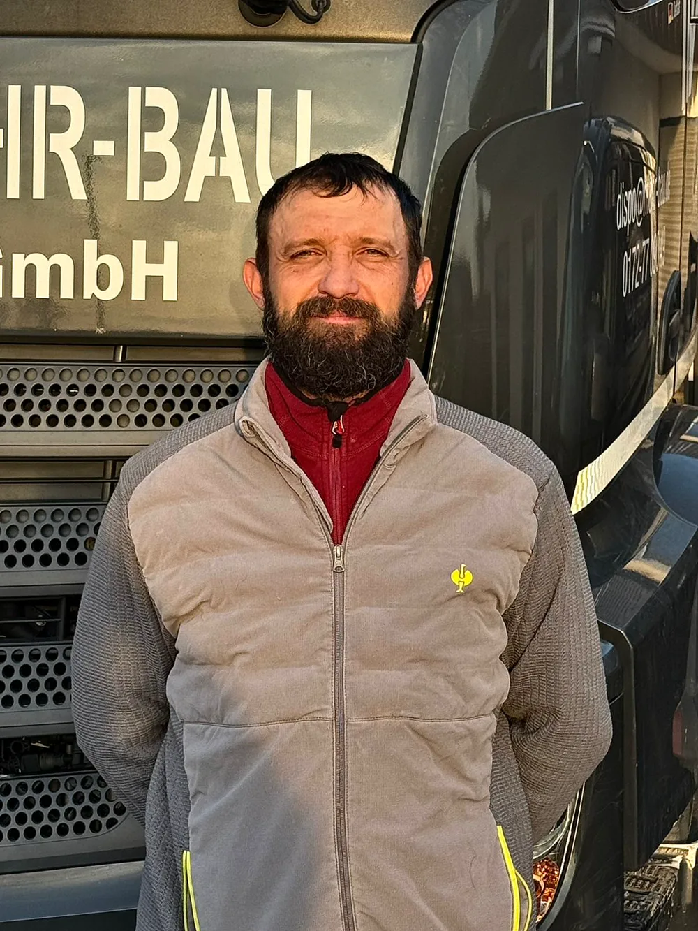 Andrii, Mitarbeiter der Mehr-Bau GmbH, vor dem Firmen-Lkw