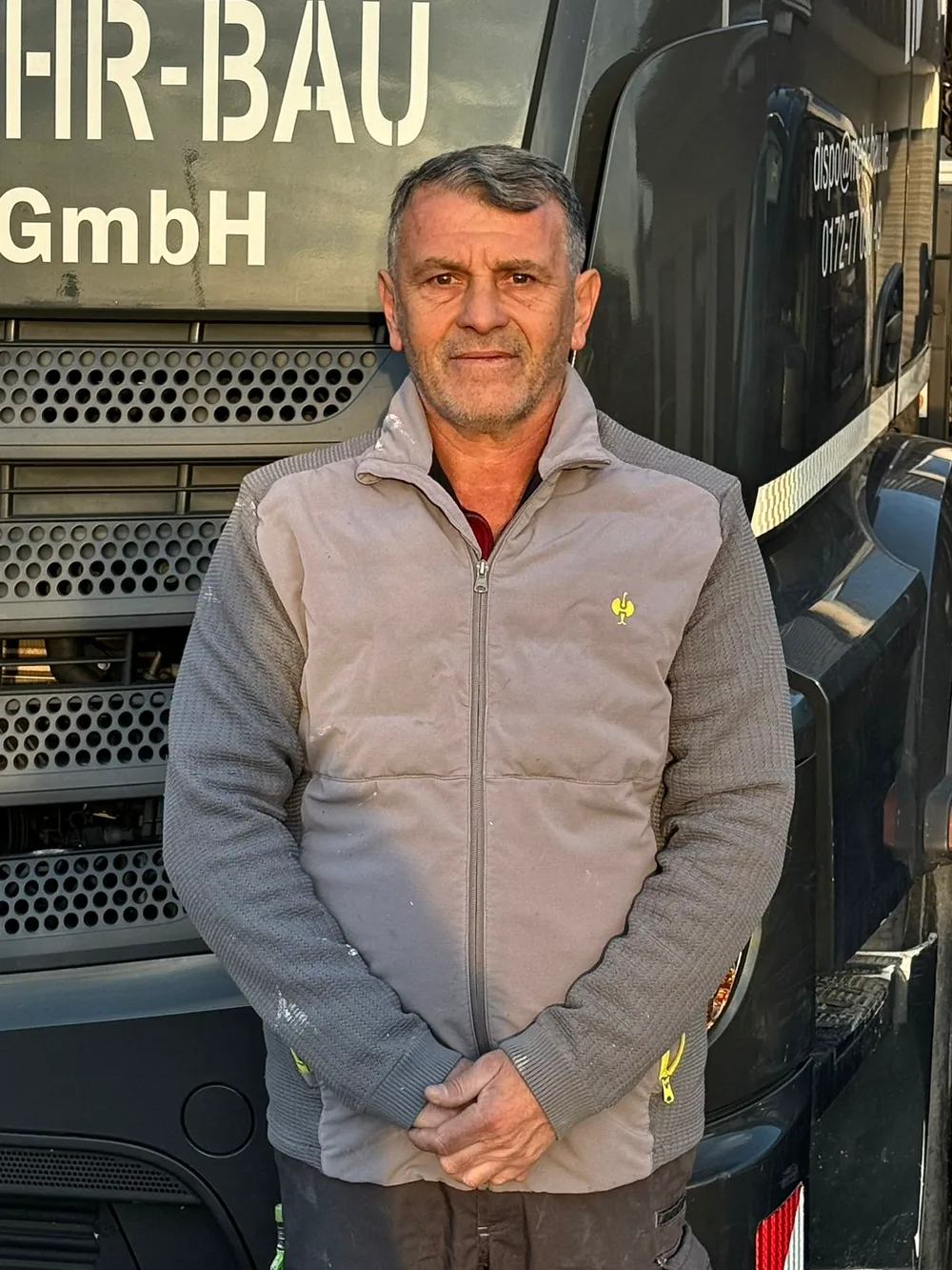 Janos, Mitarbeiter der Mehr-Bau GmbH, vor dem Firmen-Lkw