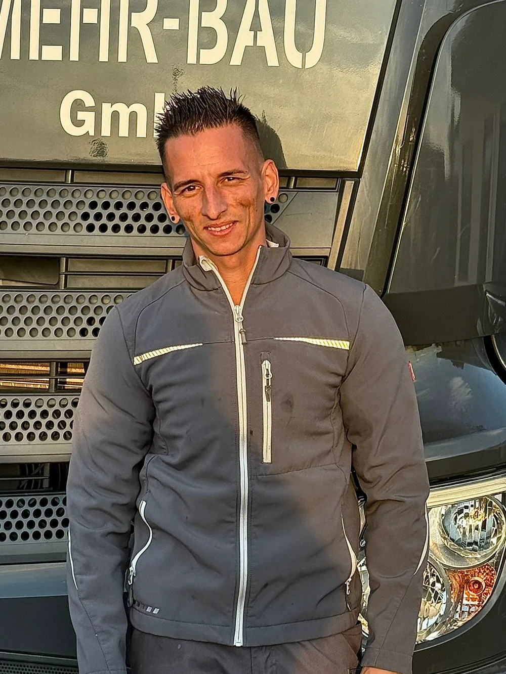 Daniel, Mitarbeiter der Mehr-Bau GmbH, vor dem Firmen-Lkw