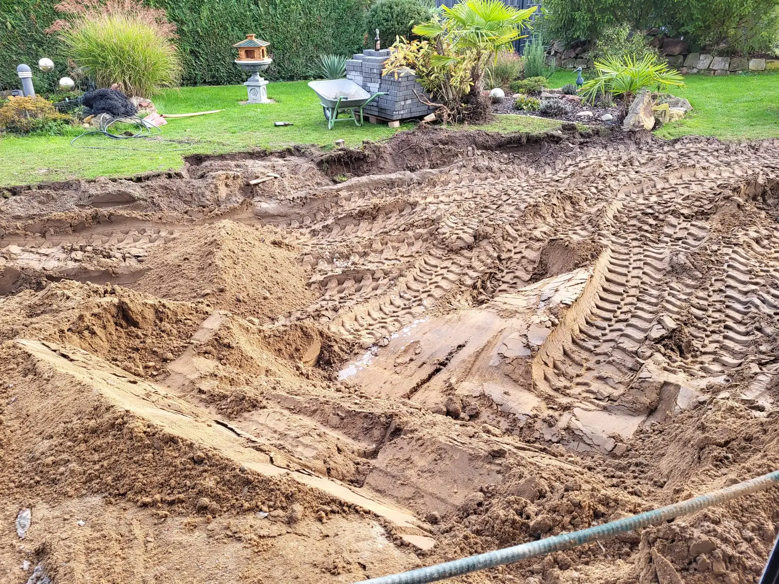 Freigeräumtes Erdreich im Garten nach dem Rückbau, Baggerspuren im Boden