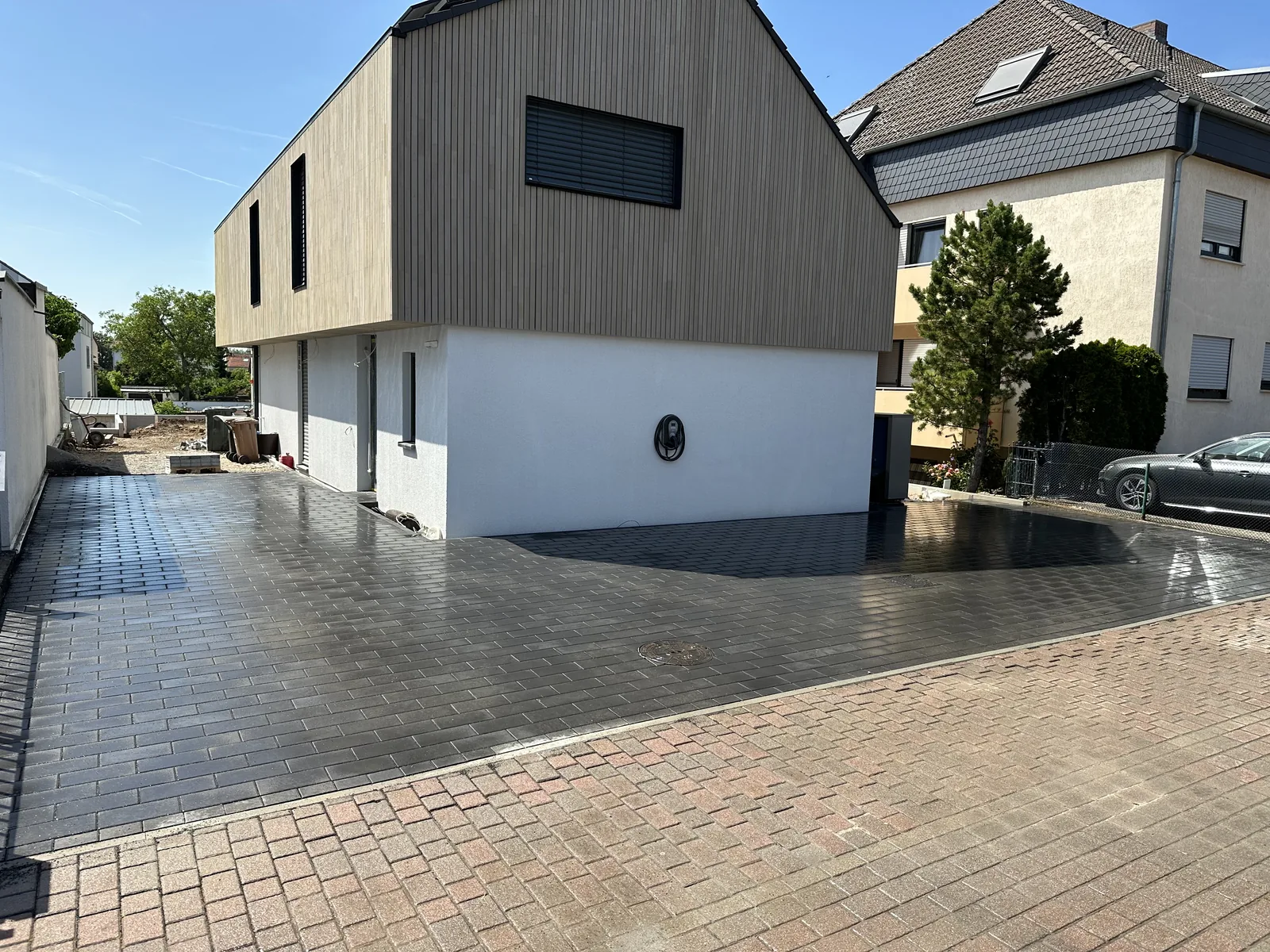 Fertige Pflasterfläche mit Zufahrt und Vorplatz vor dem Neubau