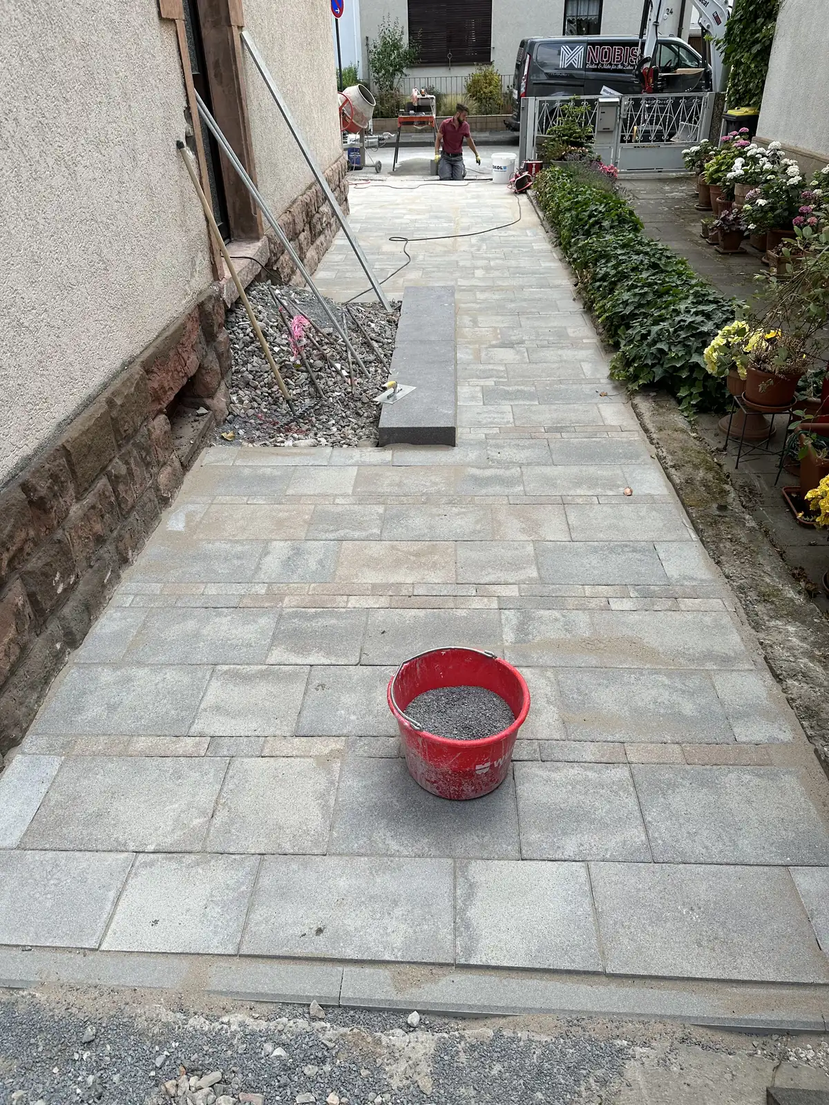 Fertig belegter schmaler Weg zwischen Hauswand und Grundstücksgrenze