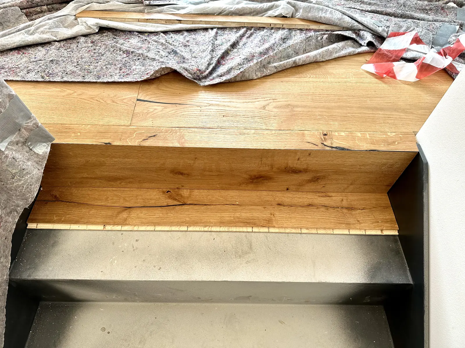 Detail einer mit Eiche belegten Treppenstufe auf der Stahlwange
